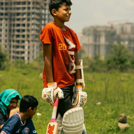 pexels-photo-13079894-13079894 Children enjoying a cricket game outdoors near city buildings.